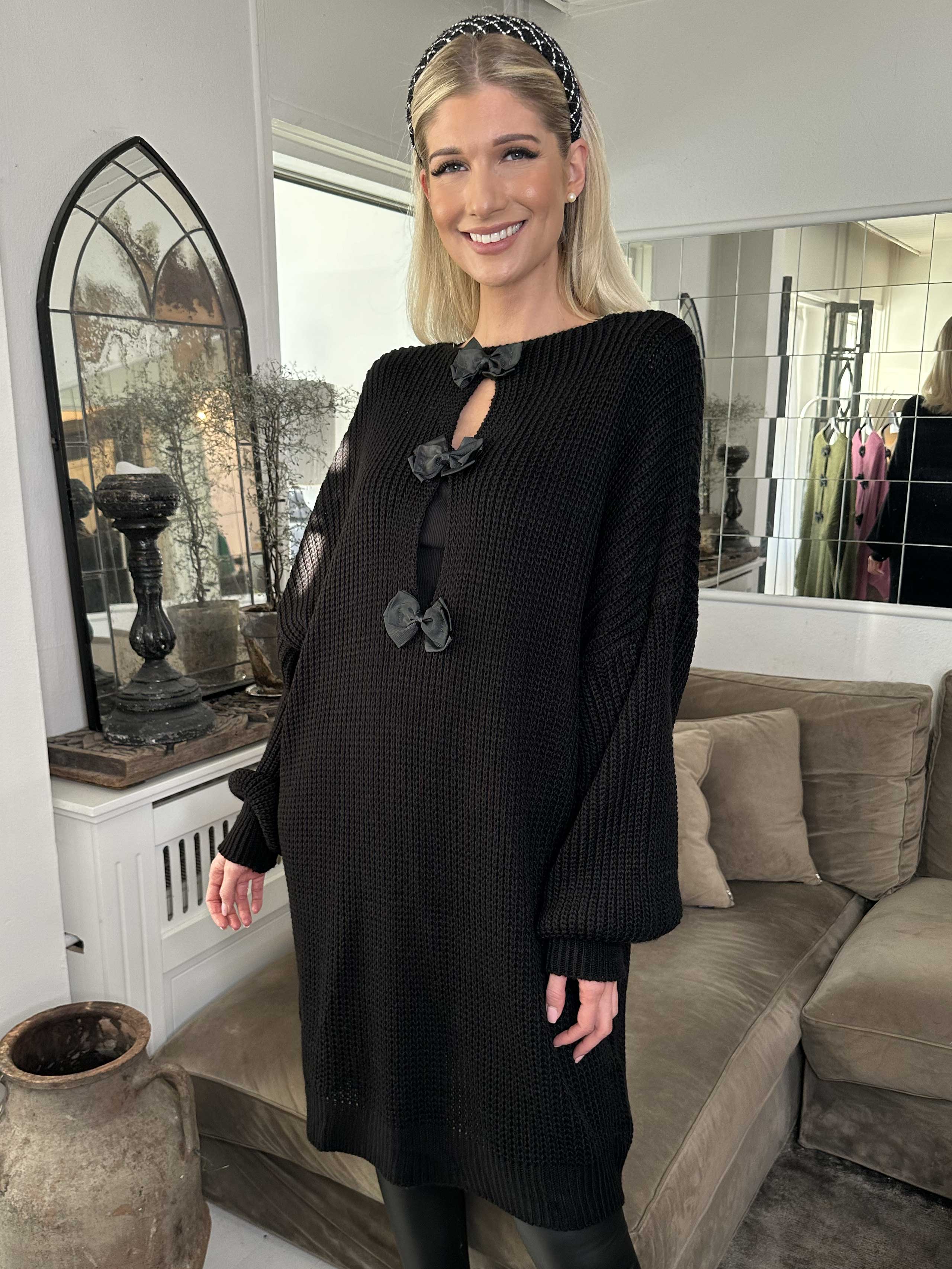 Diana - Fin stickad klänning med ballongärmar och rosetter